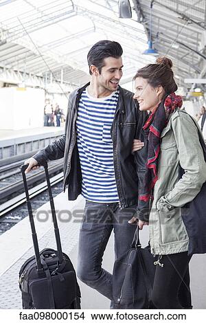 Picture - Couple with luggage on train platform. Fotosearch