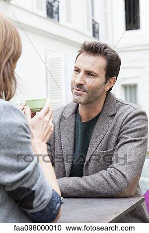 Friends chatting over coffee at cafe View Large Photo Image Stock Image - Friends chatting over coffee at cafe. Fotosearch