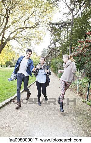 Stock Photo - Friends having fun together at park. Fotosearch