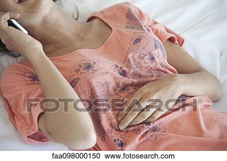 Lying on bed chatting on cell phone View Large Photo Image Stock Image - Lying on bed chatting on cell phone. Fotosearch