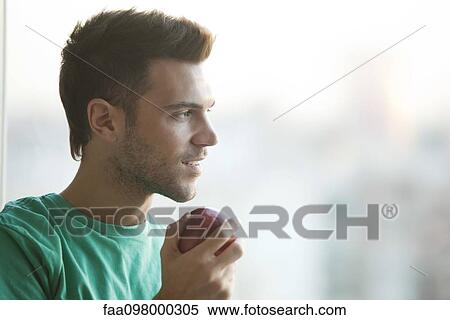Man holding apple, gazing out window View Large Photo Image Stock Photography - Man holding apple, gazing out window. Fotosearch
