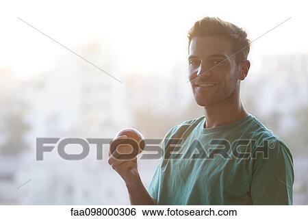 Man holding apple, portrait View Large Photo Image Stock Photograph - Man holding apple, portrait. Fotosearch