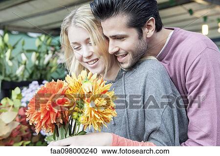 Man pleases girlfiend with surprise gift of flowers View Large Photo Image Stock Image - Man pleases girlfiend with surprise gift of flowers. Fotosearch
