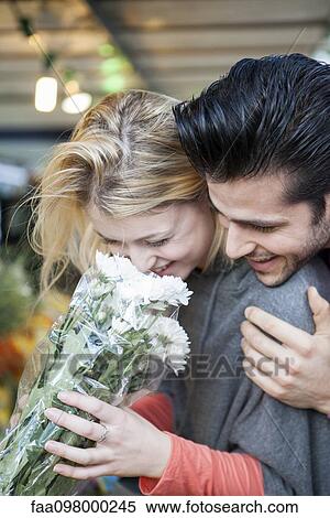 Man pleases girlfiend with surprise gift of flowers View Large Photo Image Stock Photography - Man pleases girlfiend with surprise gift of flowers. Fotosearch