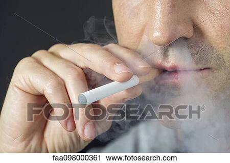 Stock Image - Man smoking electonic cigarette, cropped. Fotosearch