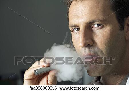 Man smoking electonic cigarette View Large Photo Image Stock Photograph - Man smoking electonic cigarette. Fotosearch