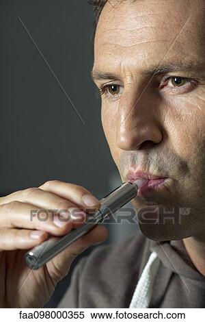 Man smoking electonic cigarette View Large Photo Image Stock Photography - Man smoking electonic cigarette. Fotosearch