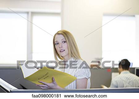 Office worker in office cubicle reviewing file View Large Photo Image Stock Image - Office worker in office cubicle reviewing file. Fotosearch