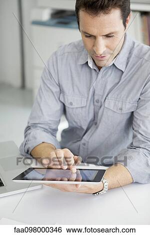 Stock Photograph - Office worker using digital tablet. Fotosearch
