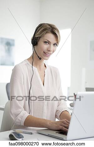 Office worker wearing phone headset multitasking View Large Photo Image Stock Image - Office worker wearing phone headset multitasking. Fotosearch