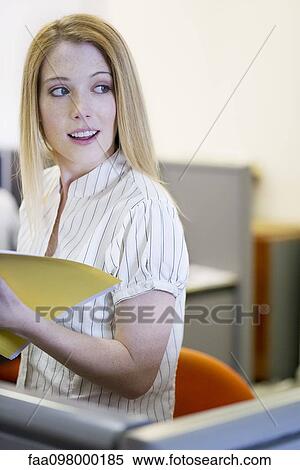 Office worker with file folder looking away distractedly View Large Photo Image Stock Photography - Office worker with file folder looking away distractedly. Fotosearch