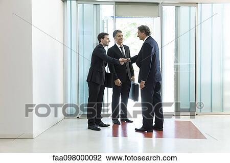 Stock Image - Senior business executive introducing new associate to collegue. Fotosearch