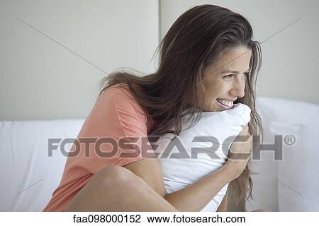 Woman hugging pillow to self View Large Photo Image Stock Image - Woman hugging pillow to self. Fotosearch