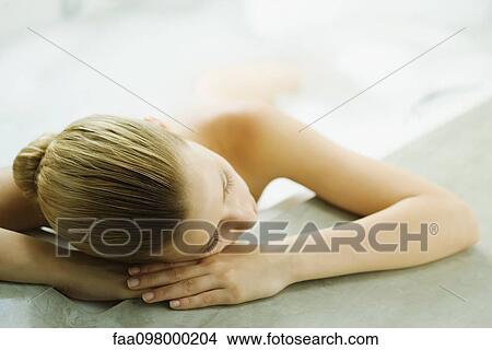 Woman in bathtub resting head on side of tub View Large Photo Image Picture - Woman in bathtub resting head on side of tub. Fotosearch