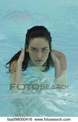 Stock Photograph - Woman in pool, looking at camera. Fotosearch