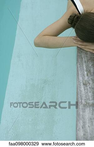 Woman lying on deck next to pool, resting head on arms View Large Photo Image Stock Photo - Woman lying on deck next to pool, resting head on arms. Fotosearch