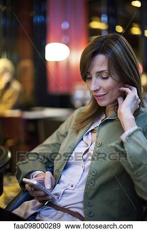 Stock Photo - Woman on shopping break using smartphone. Fotosearch