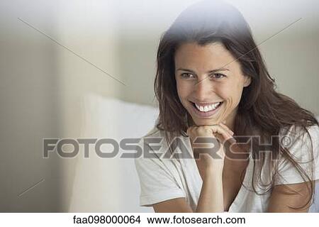 Picture - Woman resting head on chin, smiling. Fotosearch