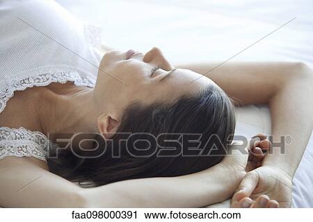 Woman resting on bed View Large Photo Image Stock Image - Woman resting on bed. Fotosearch