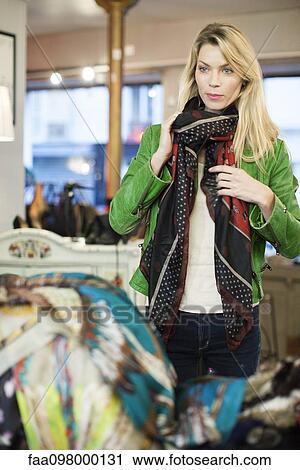 Stock Image - Woman shopping for new scarf. Fotosearch