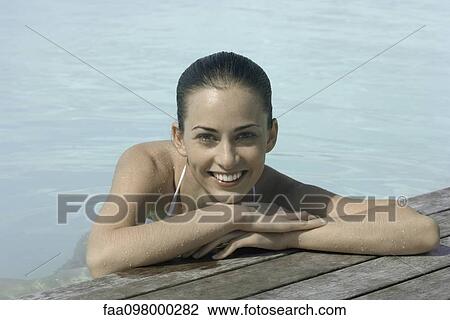 Woman soaking in pool, resting head on arms, portrait View Large Photo Image Stock Image - Woman soaking in pool, resting head on arms, portrait. Fotosearch