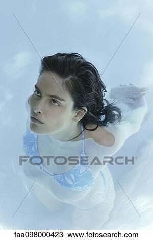 Stock Image - Woman stretching in swimming pool, high angle view. Fotosearch