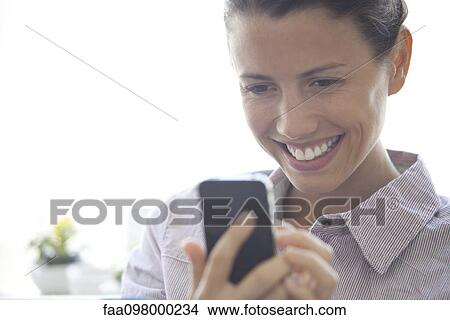 Woman text-messaging using smartphone View Large Photo Image Picture - Woman text-messaging using smartphone. Fotosearch