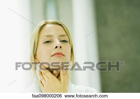 Stock Photograph - Woman touching her neck. Fotosearch