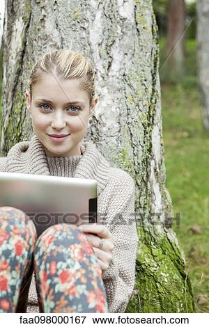 Stock Photo - Woman using digital tablet outdoors. Fotosearch
