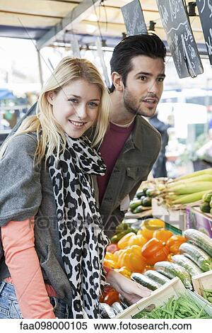 Young couple at greengrocer's shopping for fresh fruits and vegetables View Large Photo Image Stock Photography - Young couple at greengrocer's shopping for fresh fruits and vegetables. Fotosearch