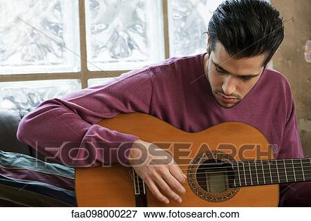 Young man playing acoustic guitar View Large Photo Image Stock Photo - Young man playing acoustic guitar. Fotosearch
