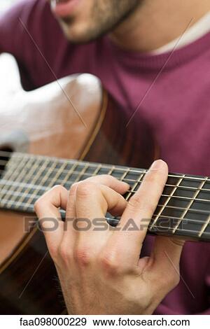 Stock Photo - Young man playing acoustic guitar. Fotosearch
