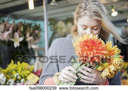Young woman appreciating flower bouquet fragrance View Large Photo Image Stock Photo - Young woman appreciating flower bouquet fragrance. Fotosearch
