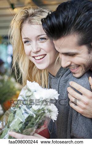 Young woman pleased after receiving flower bouquet from boyfriend View Large Photo Image Picture - Young woman pleased after receiving flower bouquet from boyfriend. Fotosearch