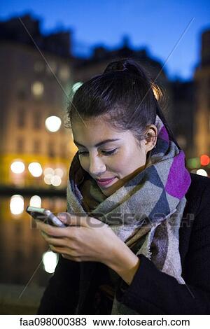 Young woman using smartphone outdoors View Large Photo Image Stock Image - Young woman using smartphone outdoors. Fotosearch