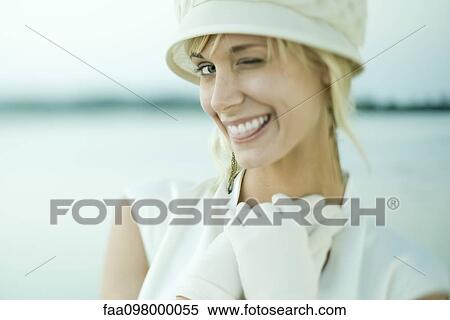 Stock Photography - Young woman winking at camera. Fotosearch