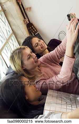 Young women looking at contents of shopping bags together View Large Photo Image Stock Photography - Young women looking at contents of shopping bags together. Fotosearch