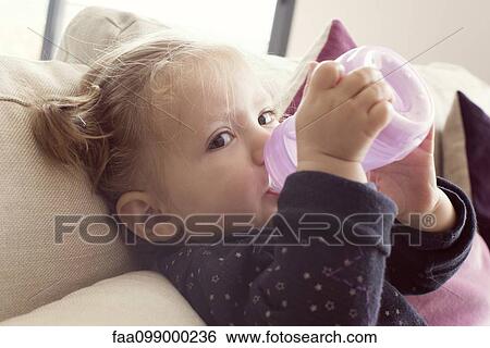 Baby girl drinking from bottle View Large Photo Image Stock Photograph - Baby girl drinking from bottle. Fotosearch