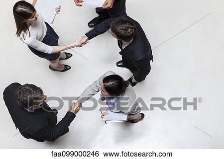 Business associates shaking hands, overhead view View Large Photo Image Stock Photograph - Business associates shaking hands, overhead view. Fotosearch