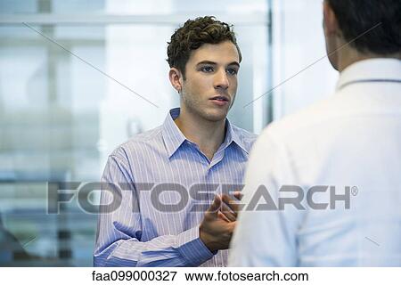 Business colleagues chatting in office View Large Photo Image Stock Photo - Business colleagues chatting in office. Fotosearch