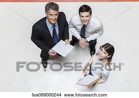 Business colleagues talking together, smiling up at camera View Large Photo Image Picture - Business colleagues talking together, smiling up at camera. Fotosearch