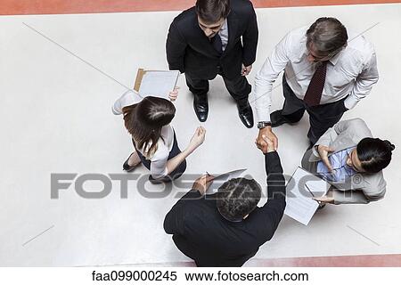 Business executives shaking hands, overhead view View Large Photo Image Stock Photography - Business executives shaking hands, overhead view. Fotosearch
