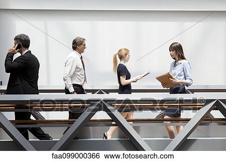 Business professionals walking through corridor View Large Photo Image Stock Photograph - Business professionals walking through corridor. Fotosearch