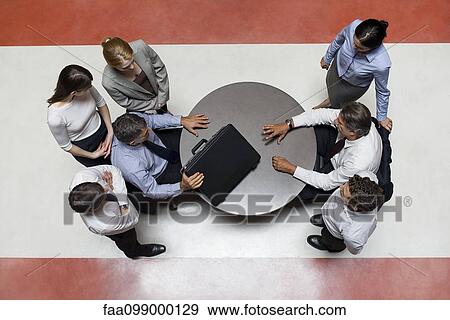 Businessman flanked by support staff considers opponents offered deal View Large Photo Image Stock Photo - Businessman flanked by support staff considers opponents offered deal. Fotosearch