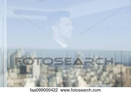 Stock Image - Businessman looking through window. Fotosearch