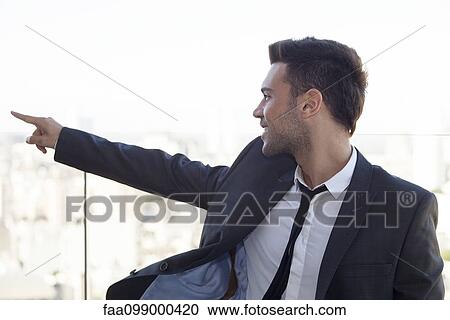Businessman on rooftop, pointing at view View Large Photo Image Stock Image - Businessman on rooftop, pointing at view. Fotosearch