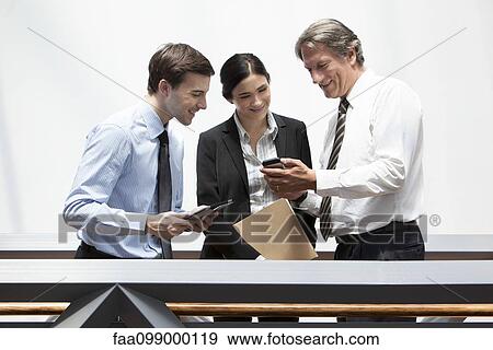 Stock Photo - Businessman showing smartphone to colleagues. Fotosearch