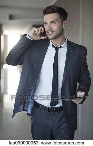 Businessman taking phone call on the move View Large Photo Image Stock Image - Businessman taking phone call on the move. Fotosearch