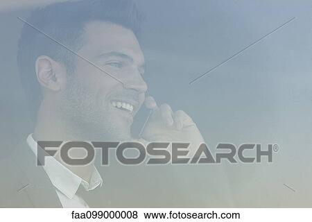 Businessman talking on cell phone, smiling cheerfully View Large Photo Image Stock Photo - Businessman talking on cell phone, smiling cheerfully. Fotosearch