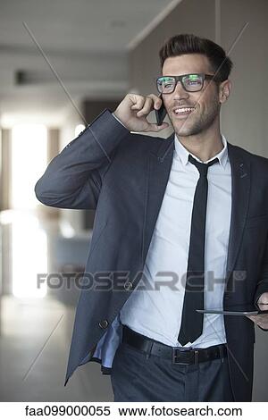 Businessman talking on cell phone, digital tablet in hand View Large Photo Image Stock Photography - Businessman talking on cell phone, digital tablet in hand. Fotosearch